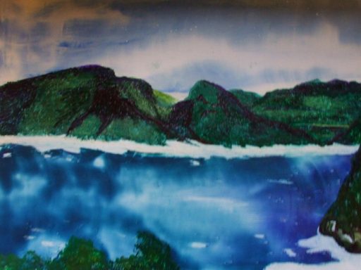 Encaustic wax painting with oil pastel detail showing the Cape area of Hout Bay. Blue sky and clouds against green mountains and blue sea.